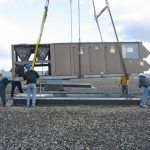 The technicians put one of the five 40-ton rooftop HVAC units in place on the newly reinforced roof